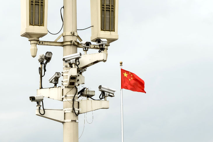 Surveillance cameras with a Chinese flag in the background.
